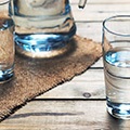 Houte tafel met daarop drie glazen gevuld met water
