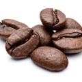 Een klein hoopje bruine koffiebonen, vol met cafeine