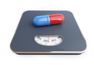 Een weegschaal met daarop een rood met blauwe capsule