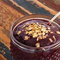 Een schaaltje yoghurt gemixt met acai bessen en wat granen erover heen Een schaaltje yoghurt gemixt met acai bessen en wat granen erover heen