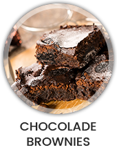 Een houte tafel met daarop een bord met een stapeltje brownies Een houte tafel met daarop een bord met een stapeltje brownies