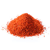 Een hoopje oranje capsicum poeder op een witte achtergrond Een hoopje oranje capsicum poeder op een witte achtergrond