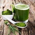 Tafel met chlorella poeder, sprieten en een glas met groene smoothie