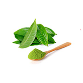 Een kleine houte lepel met groene thee poeder en een paar groene blaadjes