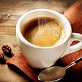 Een erg heet kopje koffie met daarnaast een kleine lepel
