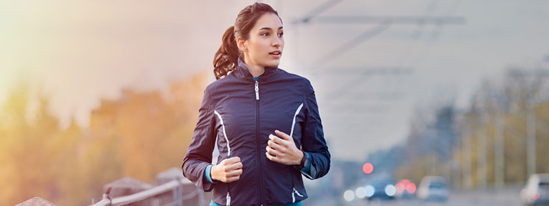 Vrouw die op een brug aan het joggen is en om haar heen kijkt