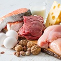Tafel met voeding vol koolhydraten zoals kaas, vlees, kip, zalm, eieren en noten