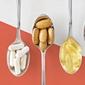 Een lepel met witte tabletten, een met bruine tabletten en een met gele tabletten