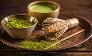 Dienblad met schaaltje matcha poeder, matcha thee en een mixstaaf