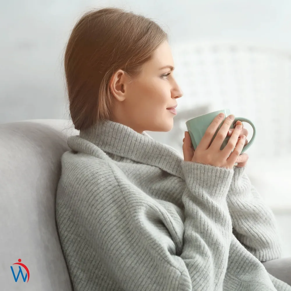 Een foto van een vrouw die een kopje matcha thee drinkt 
