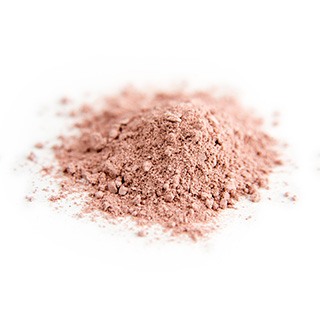 Een hoopje roze klei poeder neergelgd op een witte achtergrond Een hoopje roze klei poeder neergelgd op een witte achtergrond