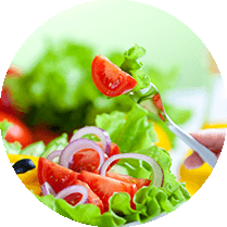 Een salada met sla, tomaat, rode uien en paprika en een vork met daarop wat sla en een stuk tomaat