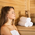 Een vrouw in een handdoek die aan het genieten is in een sauna