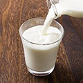 Tafel met daarop een glas melk dat wordt bijgevuld